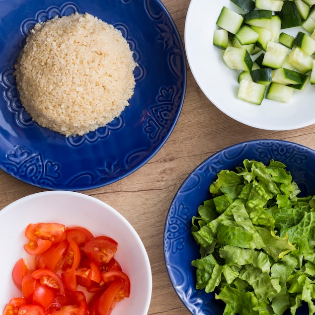 Foto grátis arroz cozido com diferentes legumes cortados em taças