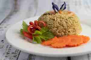 Foto grátis arroz frito de camarão em um prato branco, composto por tomates e cenouras.