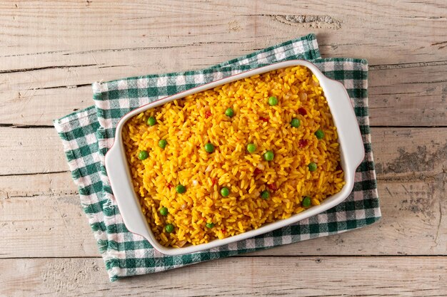 Arroz mexicano tradicional servido com ervilhas verdes na mesa de madeira