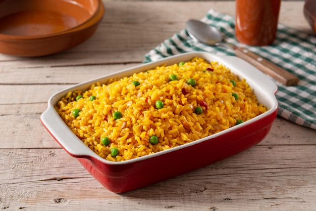 Arroz mexicano tradicional servido com ervilhas verdes na mesa de madeira