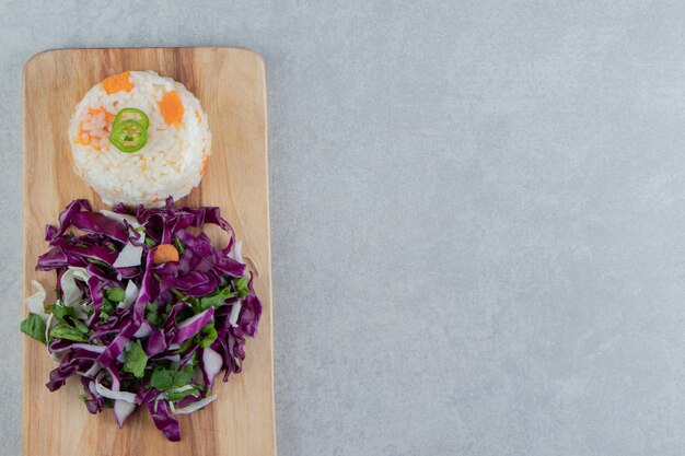 Arroz vegetariano com legumes a bordo, no fundo de mármore.