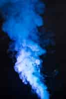 Foto grátis arte de emanações de fumo azuis brilhantes no fundo preto