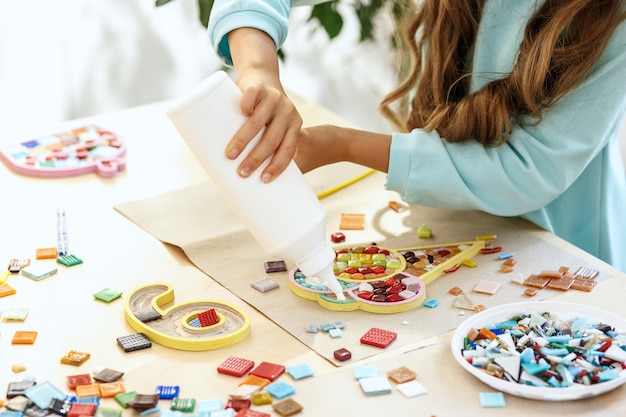 arte de quebra-cabeça de mosaico para crianças, jogo criativo infantil. mãos estão jogando mosaico na mesa. Detalhes coloridos multicoloridos close-up.