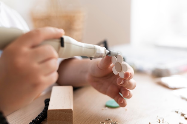 Artesã trabalhando no ateliê com pistola de cola