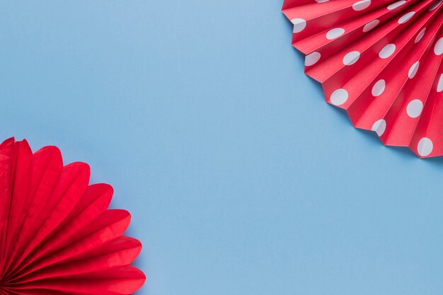 Artesanato de papel origami vermelho decorativo na superfície azul