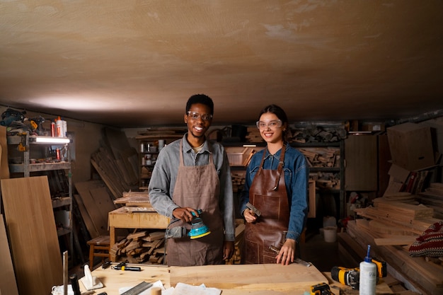 Foto grátis artesãos sorridentes de tiro médio na oficina