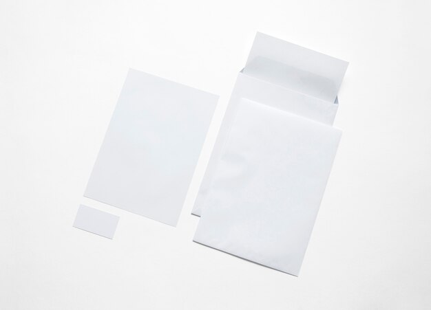 Artigos de papelaria do Livro Branco isolados no branco. Ilustração com envelopes em branco, papel timbrado e cartões para mostrar sua apresentação.