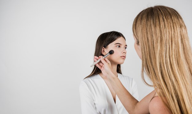 Artista aplicando blush no modelo bonito