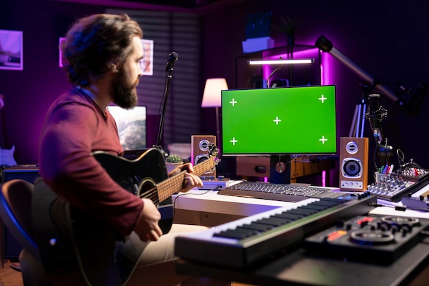 Artista aprendendo a tocar guitarra com aulas de internet em monitor de tela verde