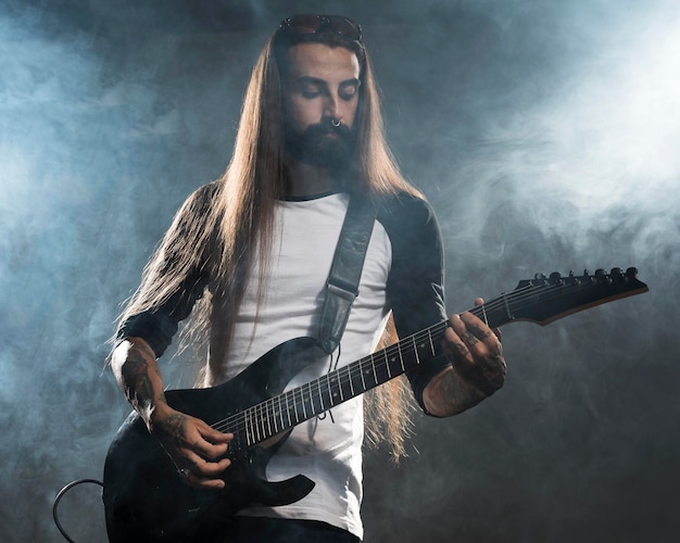 Artista com cabelo comprido tocando violão