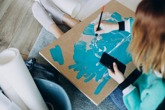 Artista de mulher pintando um quadro em casa