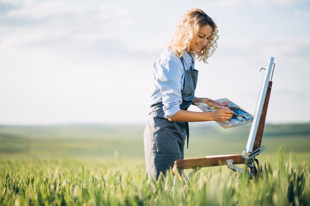 Artista de mulher, pintura com tintas a óleo em um campo