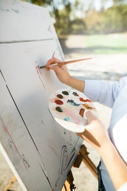 Artista feminina pintando ao ar livre