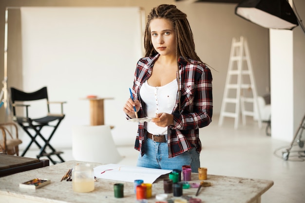 Foto grátis artista feminina pintura dentro de casa