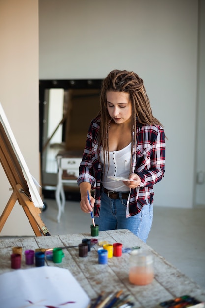 Artista feminina pintura dentro de casa