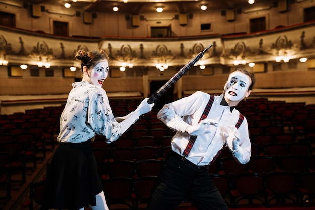 Artista feminino mime bater mime masculino com um guarda-chuva