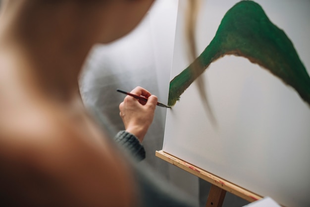 Artista feminino pintando forma verde