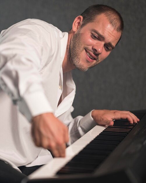 Artista lateralmente tocando várias oitavas no piano digital