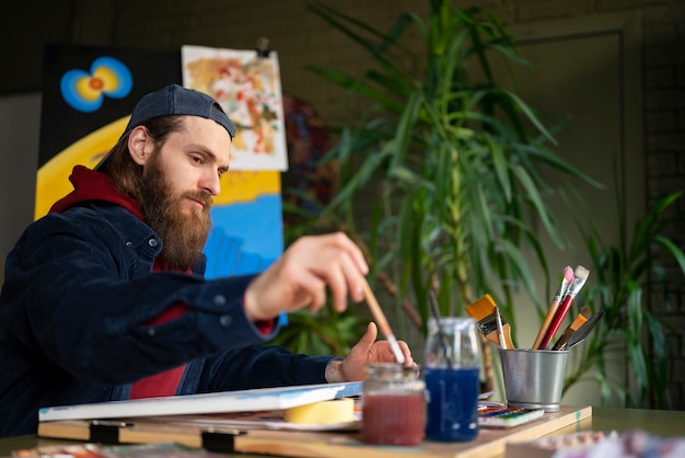 Artista masculino pintando com aquarela no estúdio