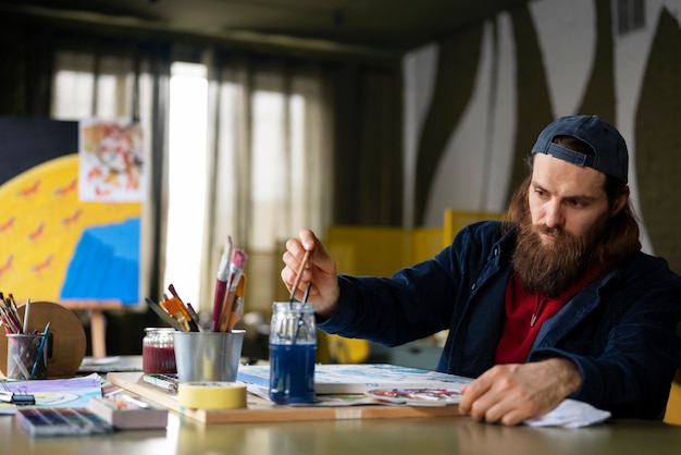 Artista masculino pintando com aquarela no estúdio