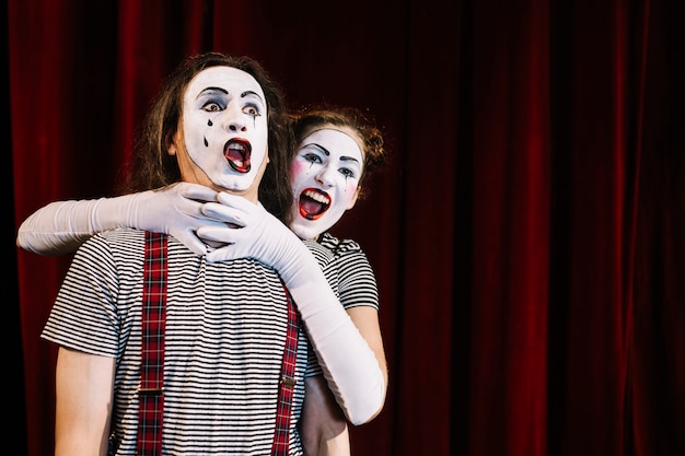 Foto grátis artista mime feminino, agarrando o pescoço do mime masculino