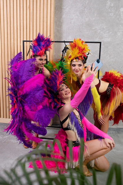 Artistas de cabaré feminino tomando uma selfie juntos nos bastidores em trajes