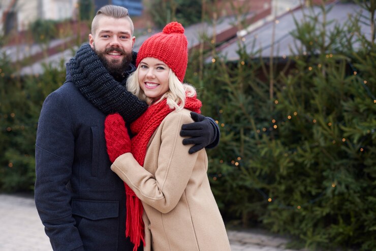 Foto grátis árvores de natal frescas e jovem casal