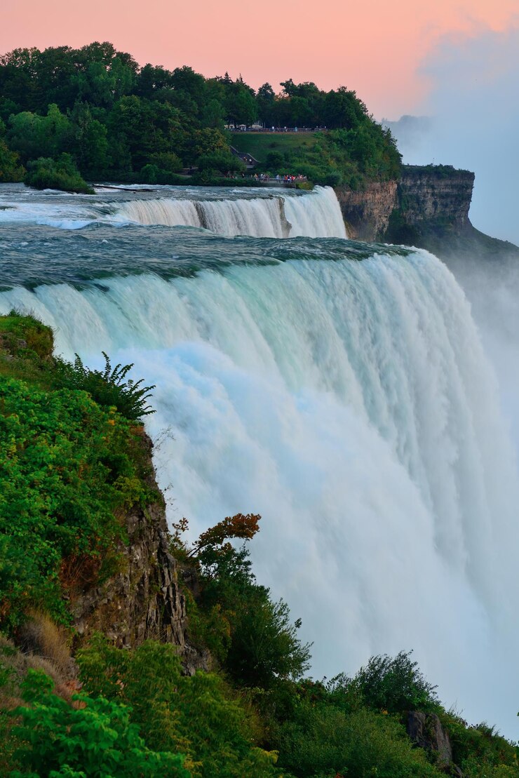 Foto grátis as cataratas americanas de niagara falls se aproximam ao anoitecer após o pôr do sol