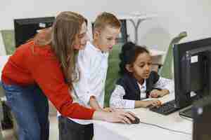 Foto grátis as crianças aprendem a trabalhar no computador. menina africana sentada à mesa. menino e menina na aula de ciência da computação.