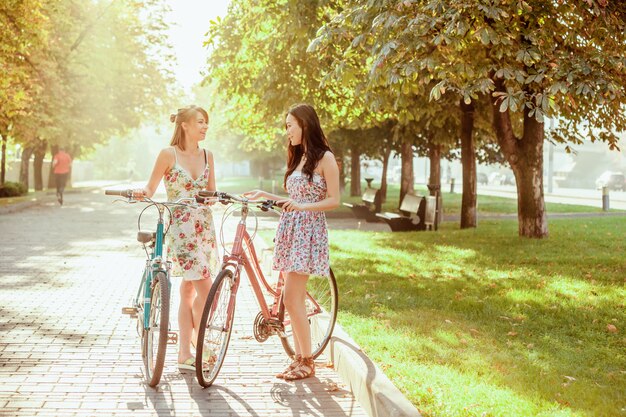 As duas meninas com bicicletas no parque