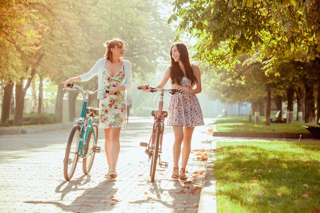 As duas meninas com bicicletas no parque