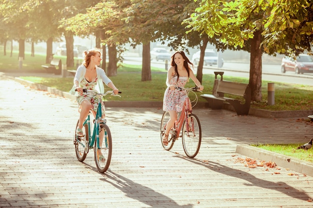 As duas meninas com bicicletas no parque