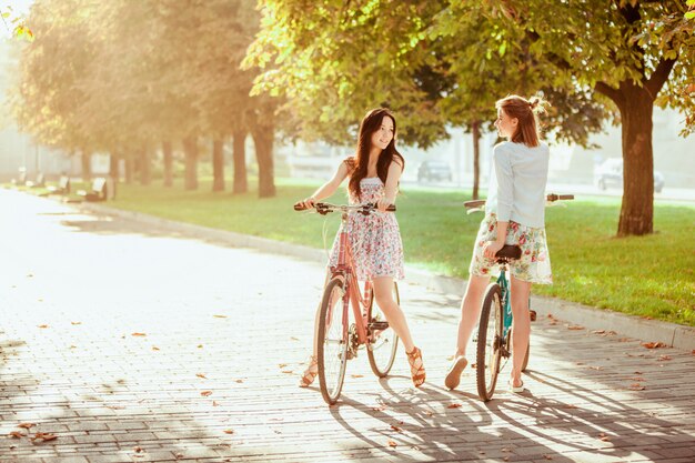 As duas meninas com bicicletas no parque