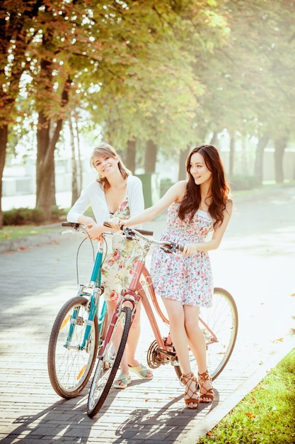 As duas meninas com bicicletas no parque