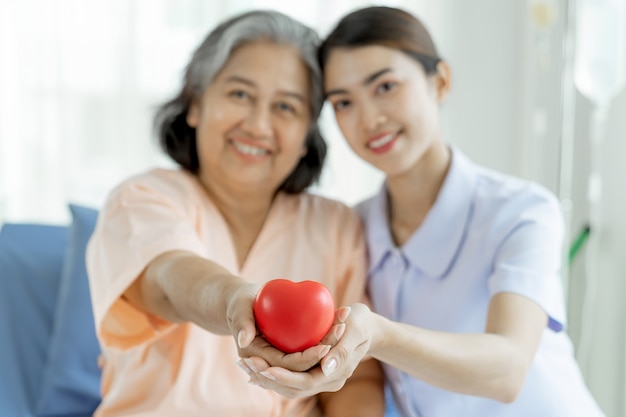 As enfermeiras cuidam bem de pacientes idosos em leitos hospitalares, sentem felicidade - conceito médico e de saúde