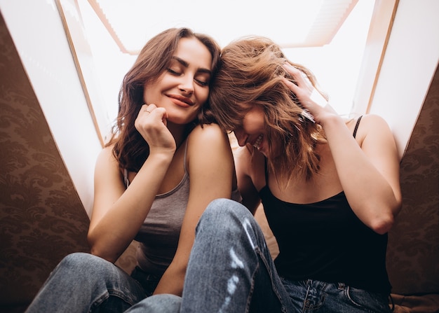 Foto grátis as lindas irmãs sorrindo e sentadas na cama