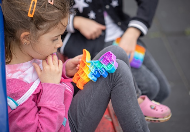 As meninas brincando com um novo brinquedo de agitação popular entre as crianças ajuda-as a se concentrar.