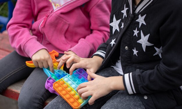 As meninas brincando com um novo brinquedo de agitação popular entre as crianças ajuda-as a se concentrar.