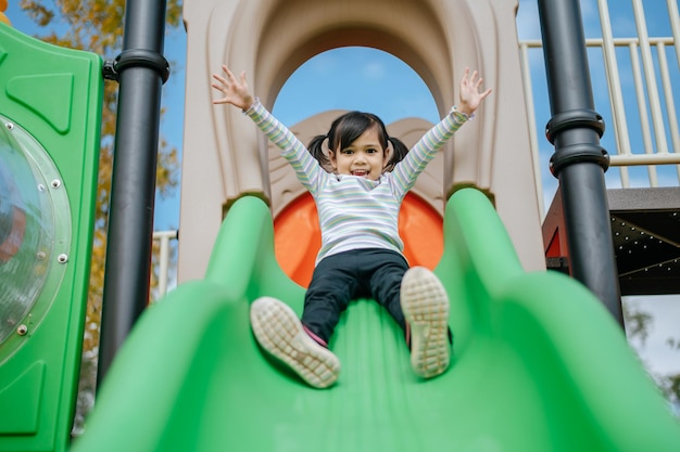 As meninas jogam slides no playground. Foco seletivo