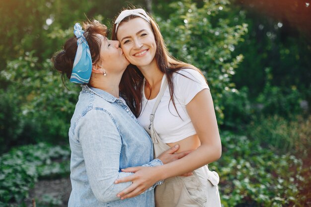 As mulheres bonitas trabalham em um jardim