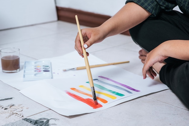 As mulheres desenham e pintam água no papel.