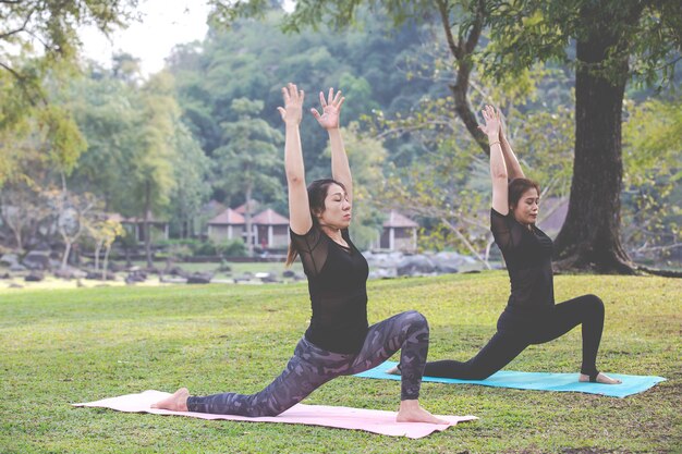 As mulheres estão jogando yoga na academia. Exercício.