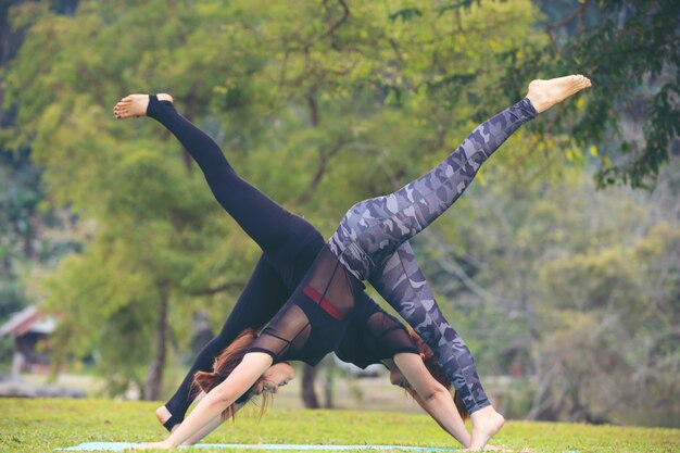 As mulheres estão jogando yoga na academia. Exercício.