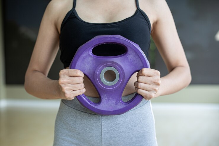 Foto grátis as mulheres exercitam com halteres no peito.