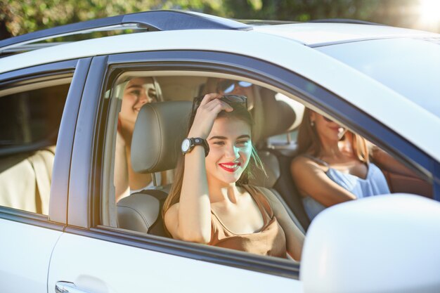 As mulheres jovens no carro sorrindo