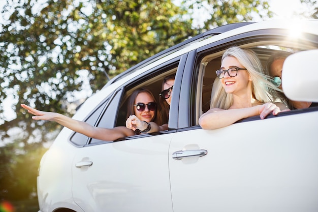 As mulheres jovens no carro sorrindo