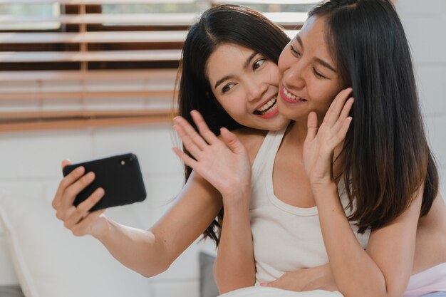 As mulheres lésbicas do lgbtq do influenciador asiático acoplam o vlog em casa.