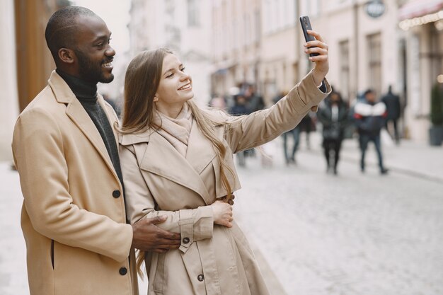 As pessoas caminham lá fora. Pessoas misturadas em uma cidade. Mulher usa um telefone.