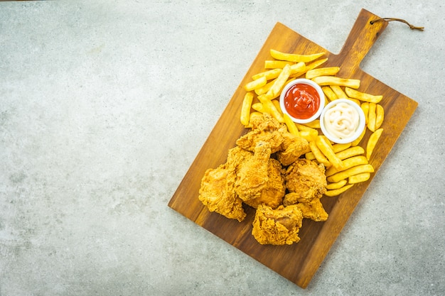 Asas de frango frito com batatas fritas e tomate