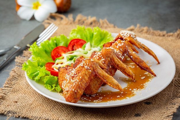 Asas de frango frito com molho de peixe e molho de peixe doce.